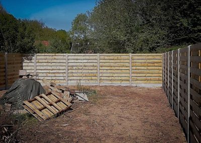 Houten-schermen-tussen-betonnen-palen na-tuinafbraak