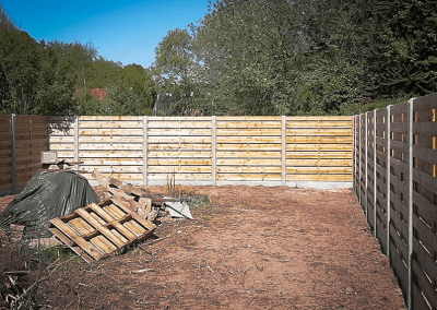 Houten-schermen-tussen-betonnen-palenna-tuinafbraak