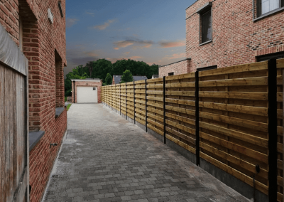 Houten-schermen-tussen-gelakte-palen-en-garage
