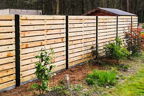 Houten schermen tussen gelakte palen